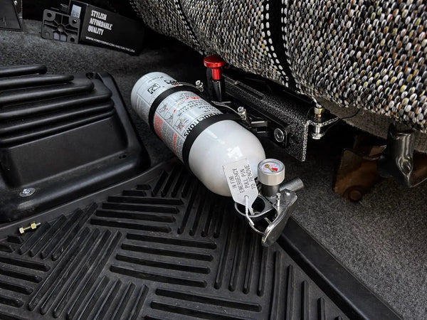 OBS Ford Fire Extinguisher Mount JC Customs—white extinguisher secured in black metal bracket under the seat