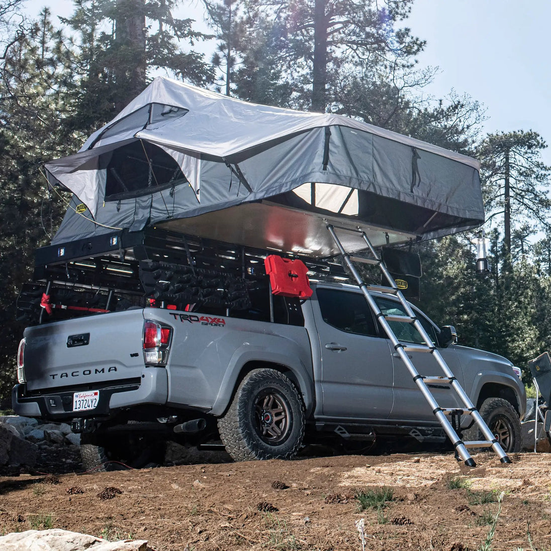 Gen2 Overlander XL rooftop tent gray by Smittybilt on a Toyota Tacoma 4x4 with ladder.