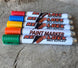 Revlock Race Supplies paint marker set, six color-coded markers with textured caps on a wooden surface