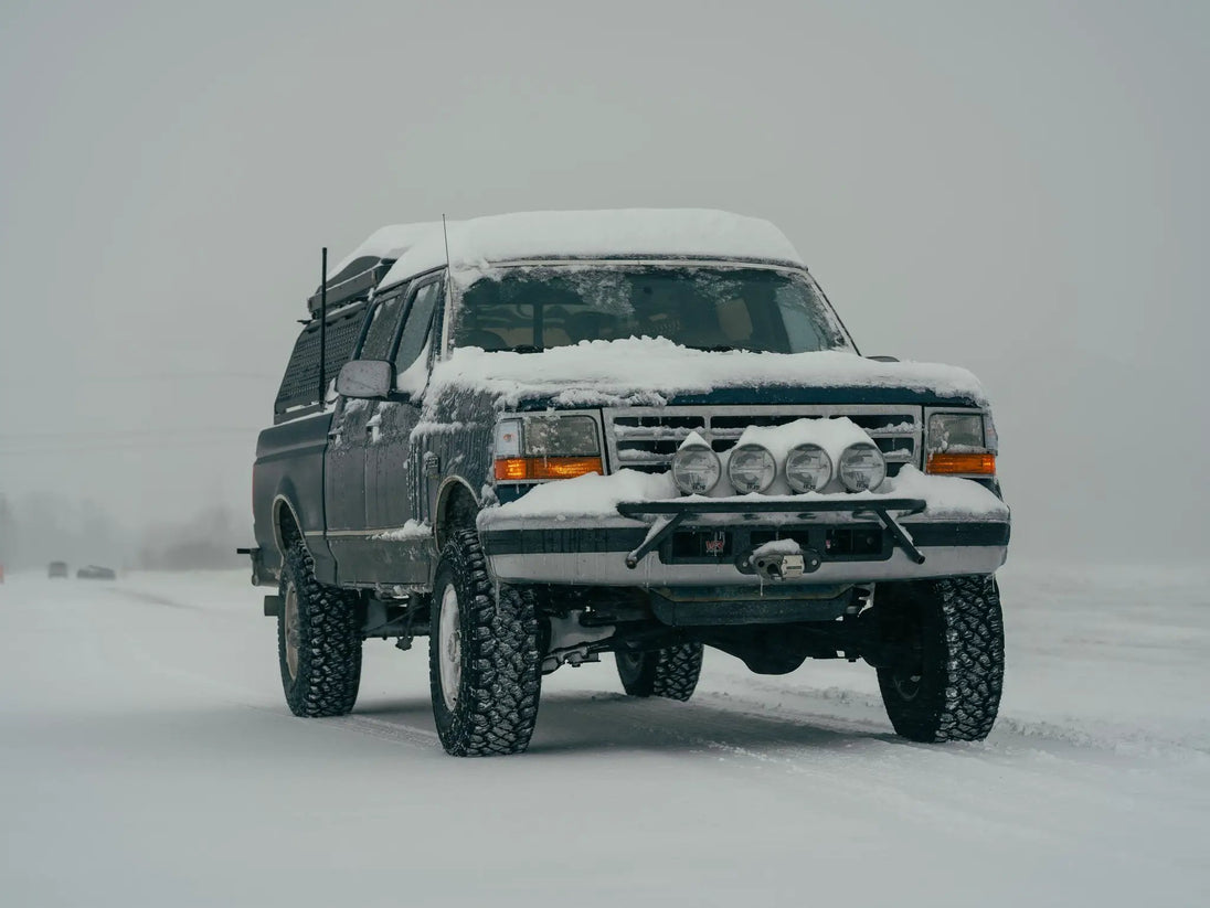 JC Customs OBS Ford Hidden Winch Mount bumper with five round lights, snow-covered front.