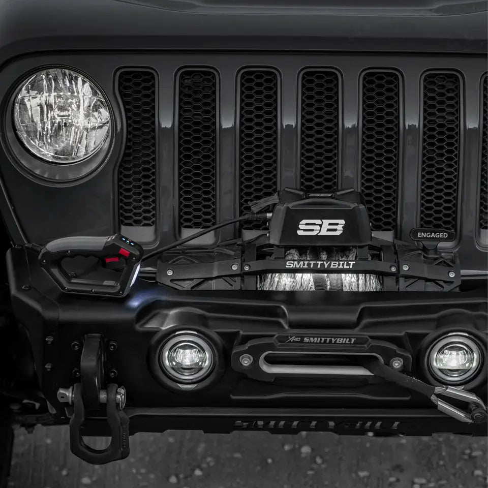 Smittybilt XRC Gen3 12K winch with synthetic cable mounted on a black off-road vehicle front bumper