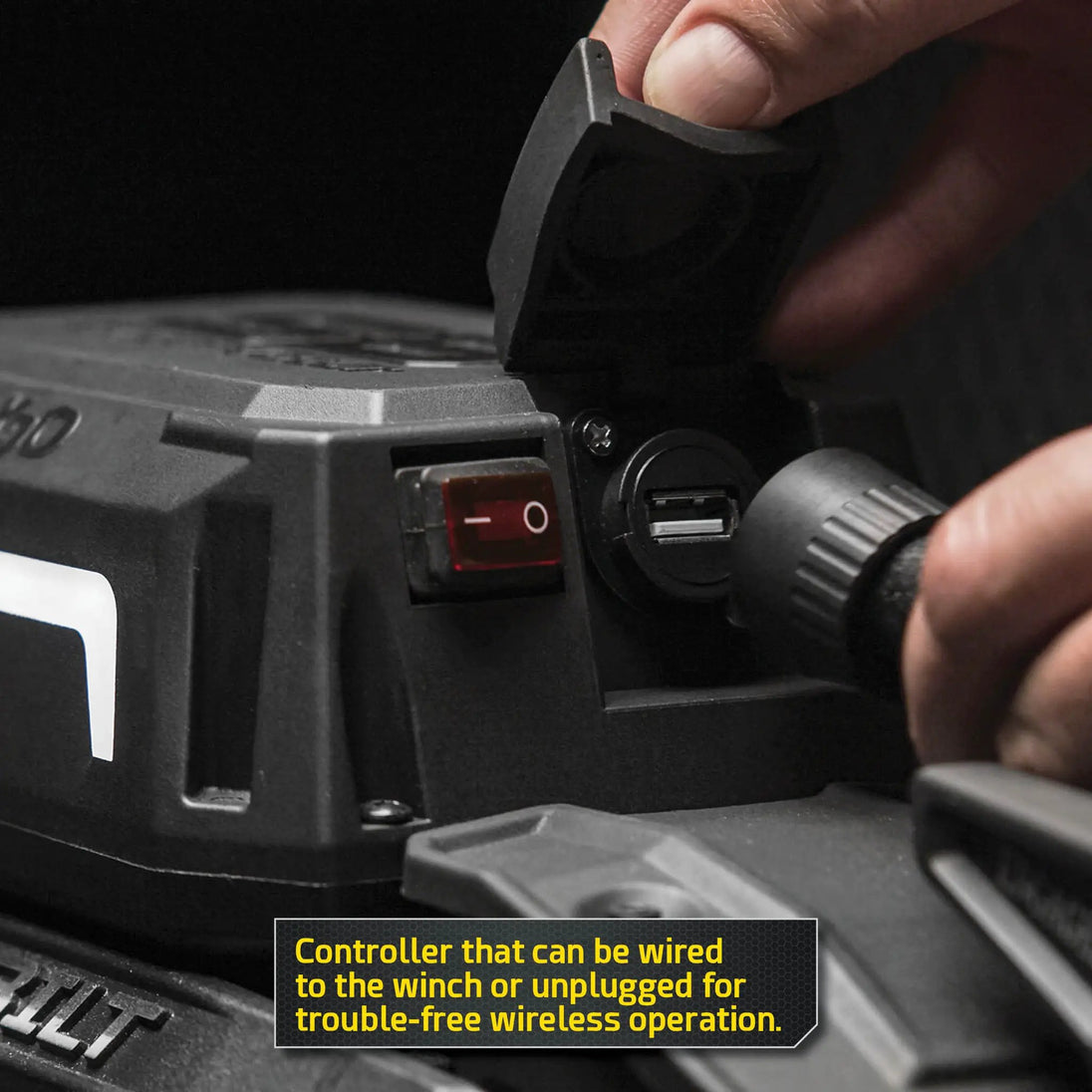 X20 Gen3 12K winch by Smittybilt being operated; hand presses red ON switch on black winch controller