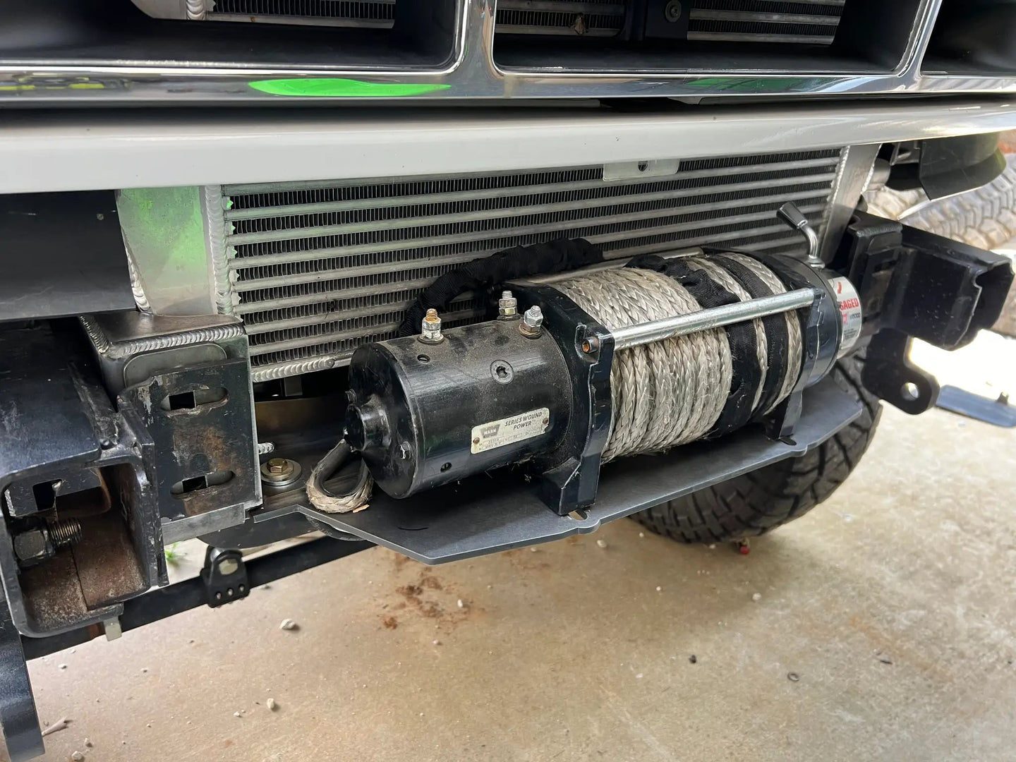 JC Customs OBS Ford Hidden Winch Mount under front bumper with winch drum and steel cable visible