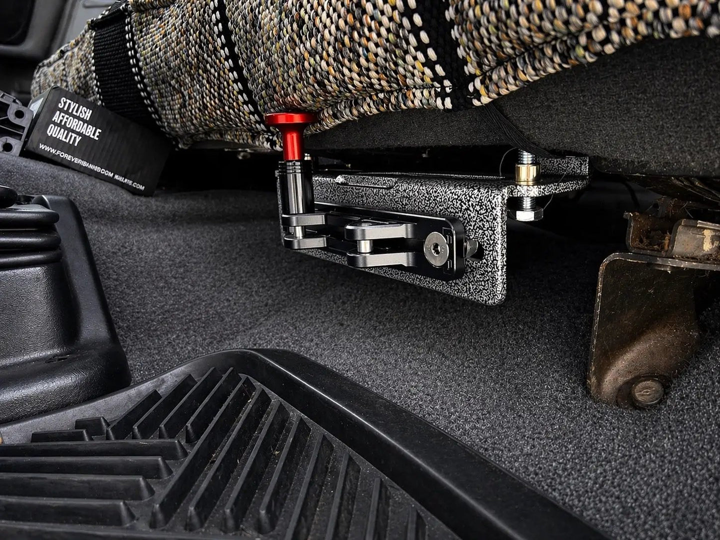 JC Customs OBS Ford Fire Extinguisher Mount under bench seat; textured black/silver bracket with red anodized knob