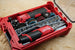 Packout SideCar Insert Milwaukee M12 FUEL 3/8 in High Speed Ratchet ScMR2567 inside red case with gray socket rail and abrasive discs