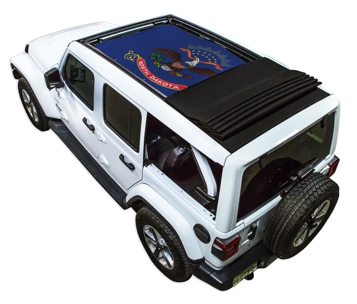 Sun shade top by SpiderWebShade for Jeep Wrangler JLU, blue North Dakota flag print on white Jeep with folded black shade.