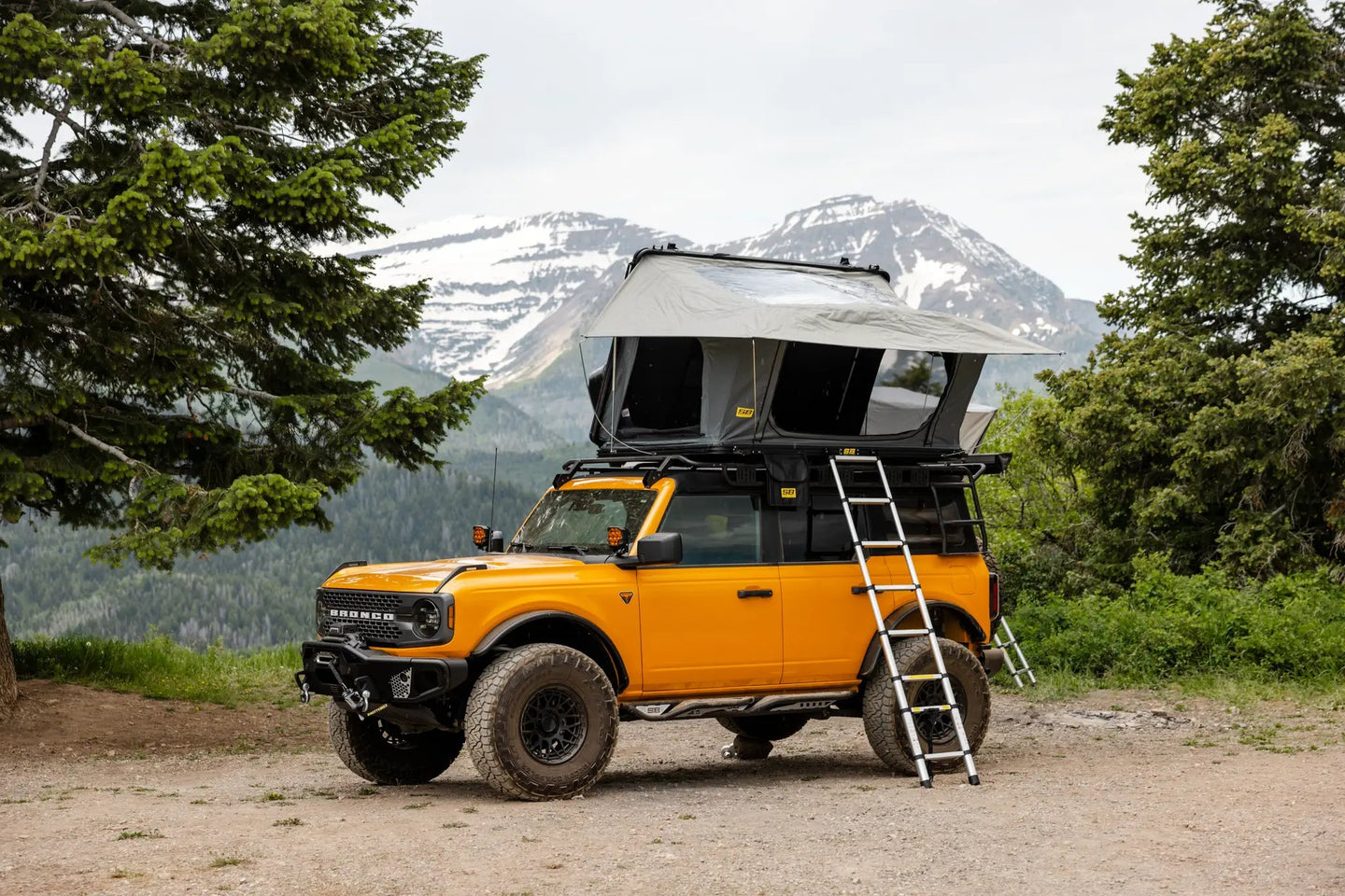 Aluminum PO Pup Roof Top Tent by Smittybilt atop a yellow Bronco, gray RTT with ladder.