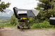 Smittybilt Overland X L hard shell tent mounted on roof rack of rugged off-road vehicle; gray with white panels