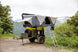 Smittybilt Overland X L hard-shell tent in gray on an off-road vehicle with ladder