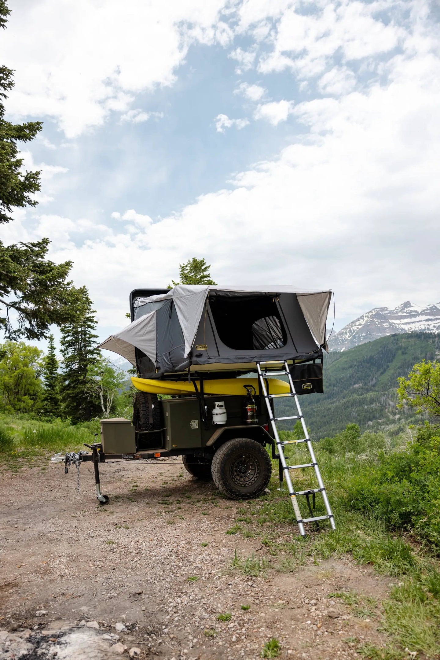 Overland X-L Hard Shell Tent on top of a rugged off-road rig with ladder, gray Smittybilt tent.