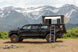 Aluminum Side Opening Roof Top Tent by Smittybilt on a black Toyota Tacoma with ladder