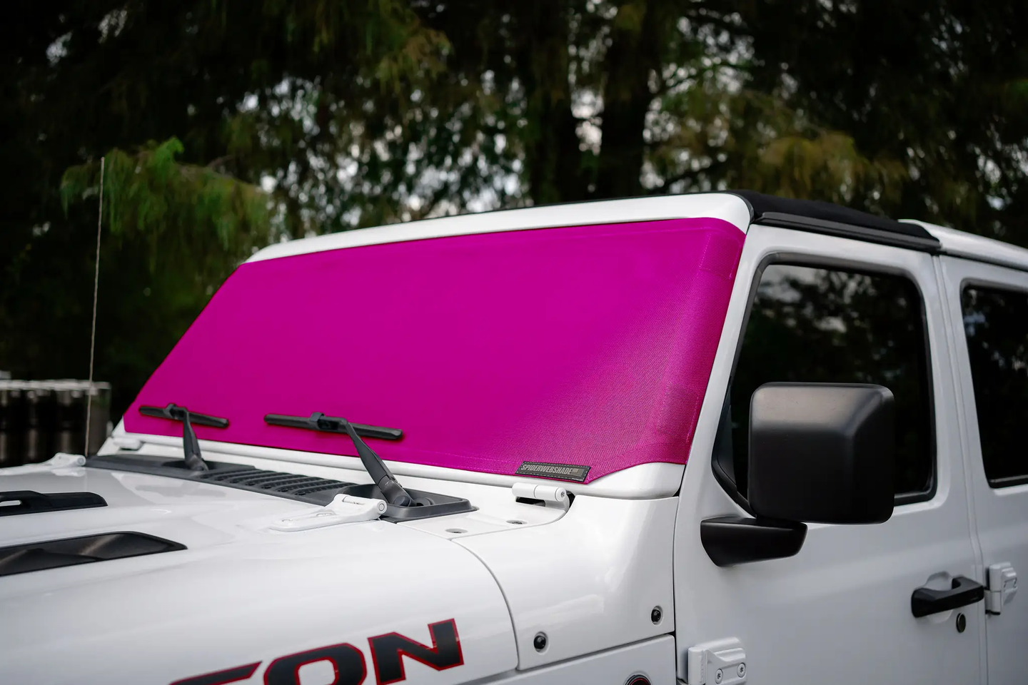 SpiderWebShade solar shade for Jeep Wrangler/Gladiator (2007-2026); bright pink windshield shade on a white Jeep