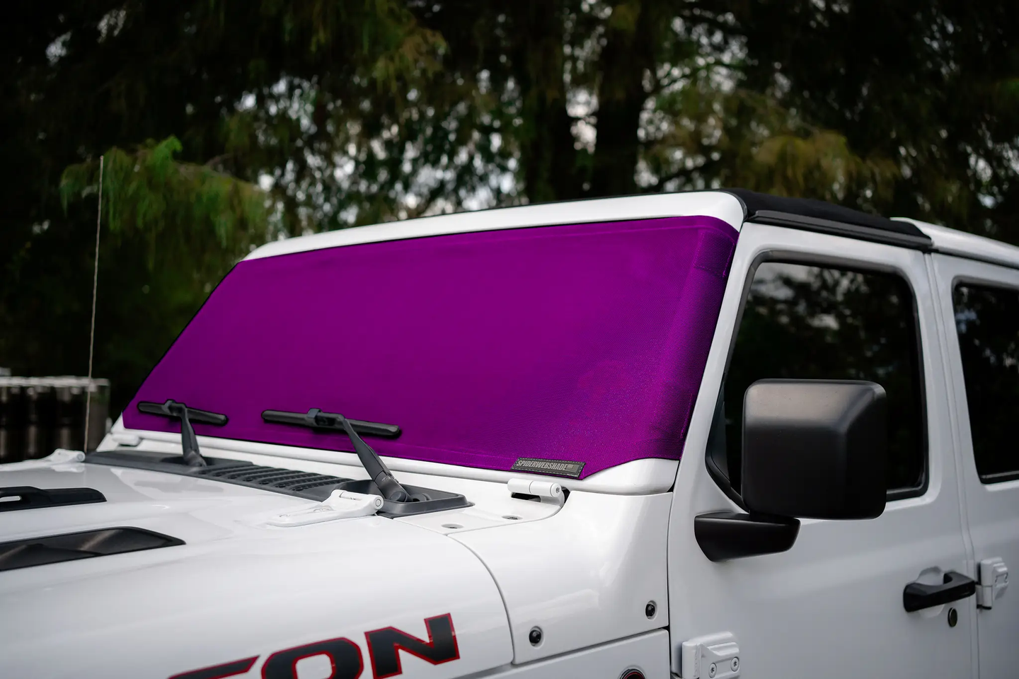Solar shade for Jeep Wrangler/Gladiator by SpiderWebShade; purple fabric shade on white Jeep.