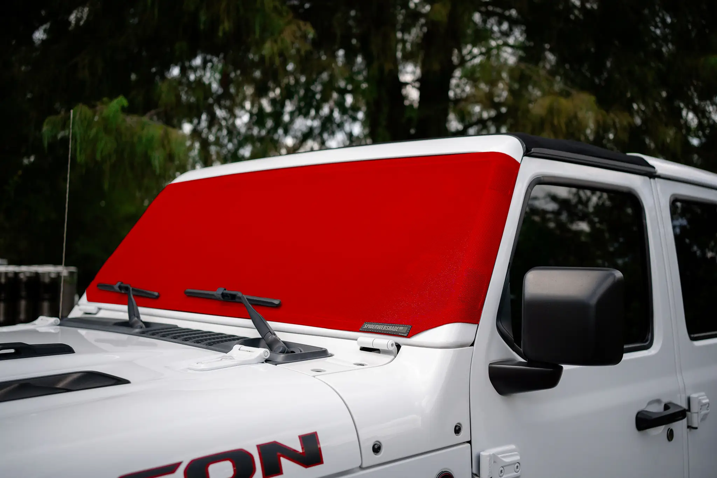 Solar Shield for Jeep Wrangler/Gladiator rear window by SpiderWebShade; red mesh shade with brand badge.