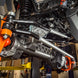Superduty Swap Aluminum Steering Kit Artec Industries undercarriage shows aluminum link, black arms, orange suspension