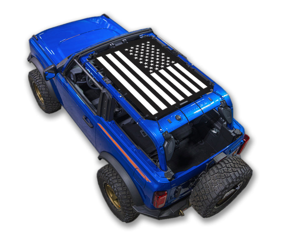 Sun shade for Ford Bronco (2021–2026) by SPIDERWEBSHADE; blue SUV with stock printed black-and-white flag top.