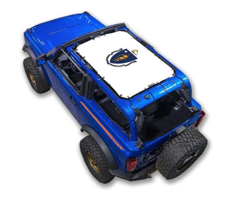 Ford Bronco sun shade top by SpiderWebShade; stock printed white shade with emblem on a blue Bronco