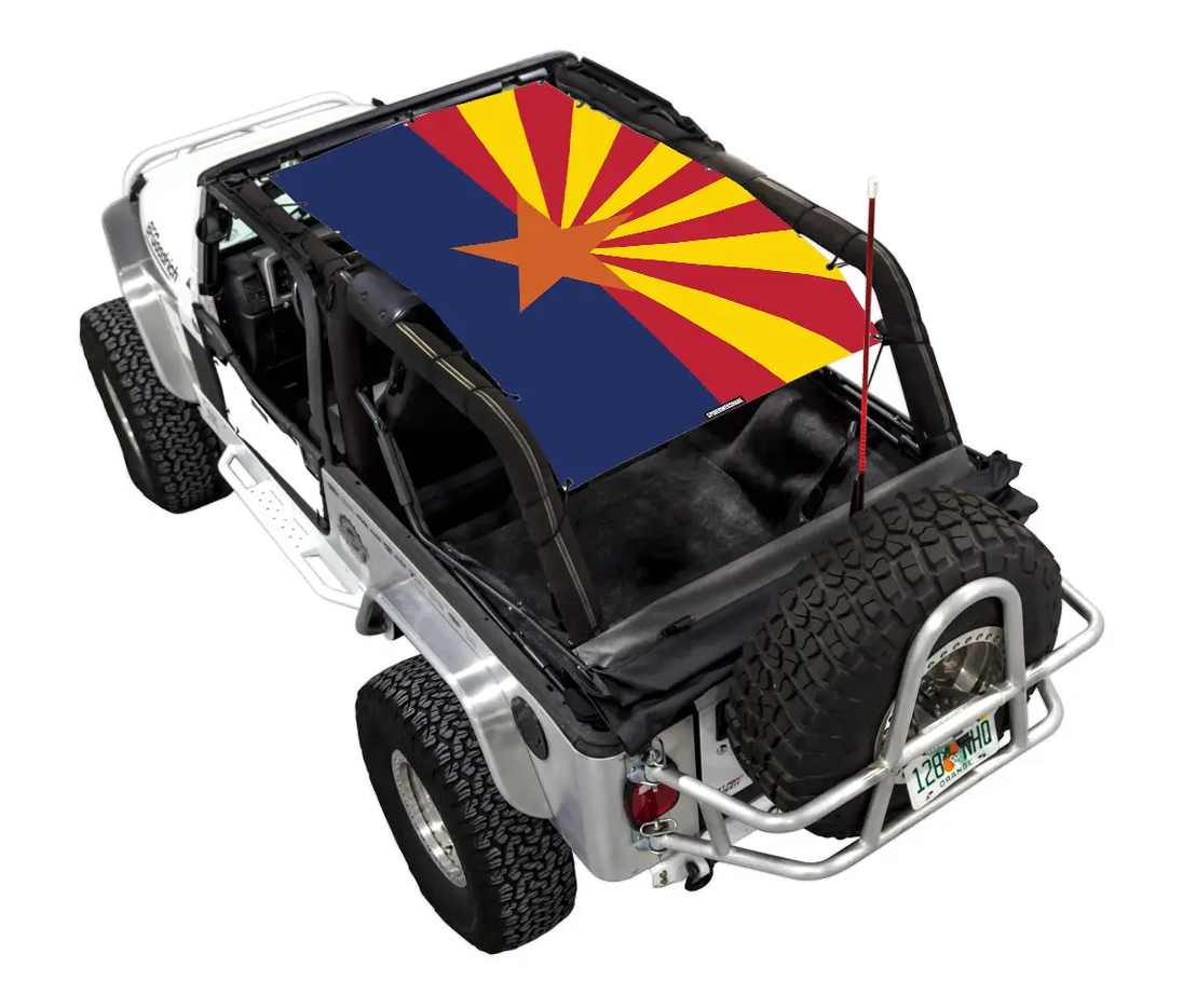 Sun shade for Jeep Wrangler LJ (2004–2006) by SPIDERWEBSHADE; printed top with blue field and yellow/red sunburst.