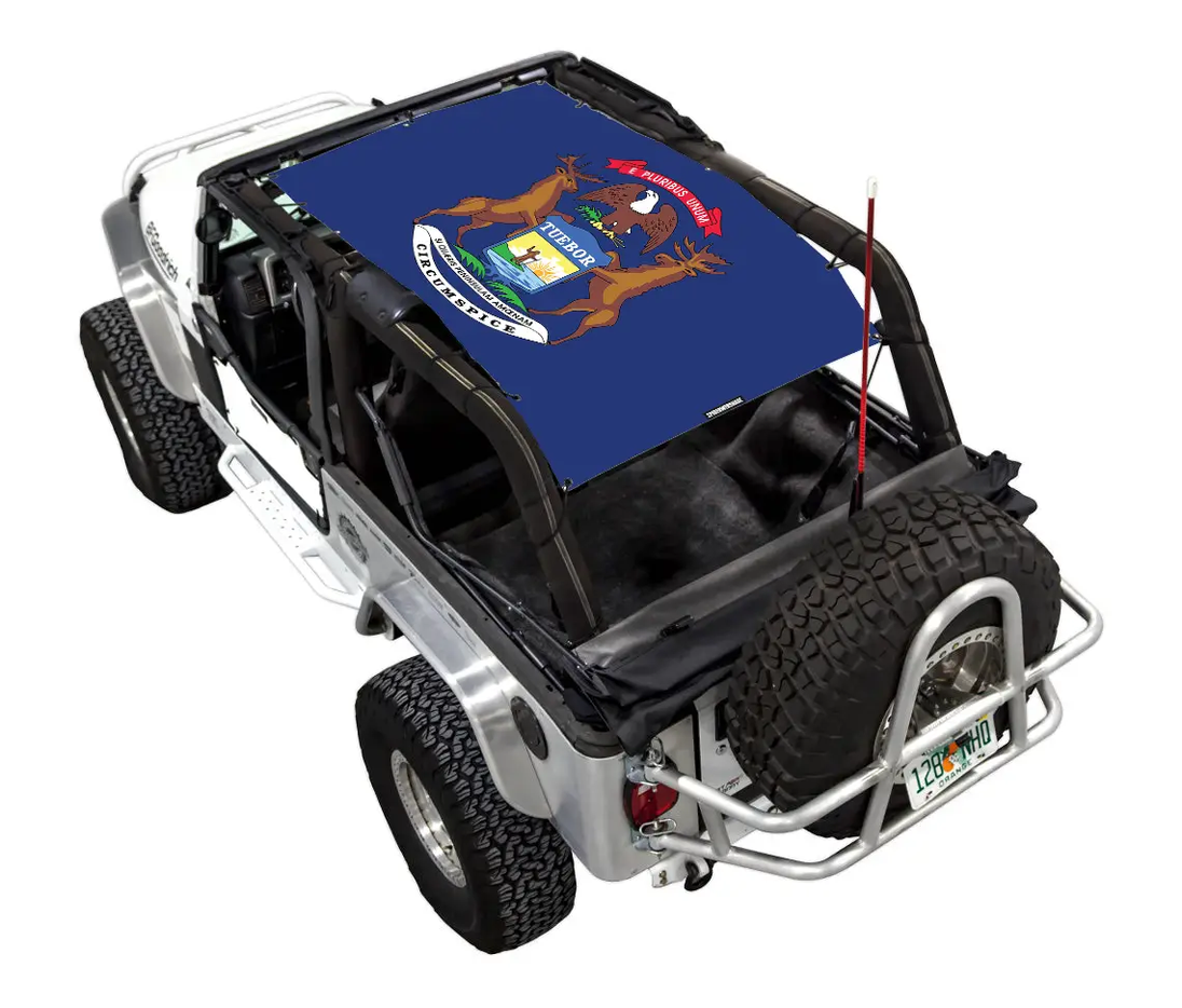 Sun shade top by SpiderWebShade for Jeep Wrangler LJ (2004–2006); blue printed shade installed over rear cargo area.