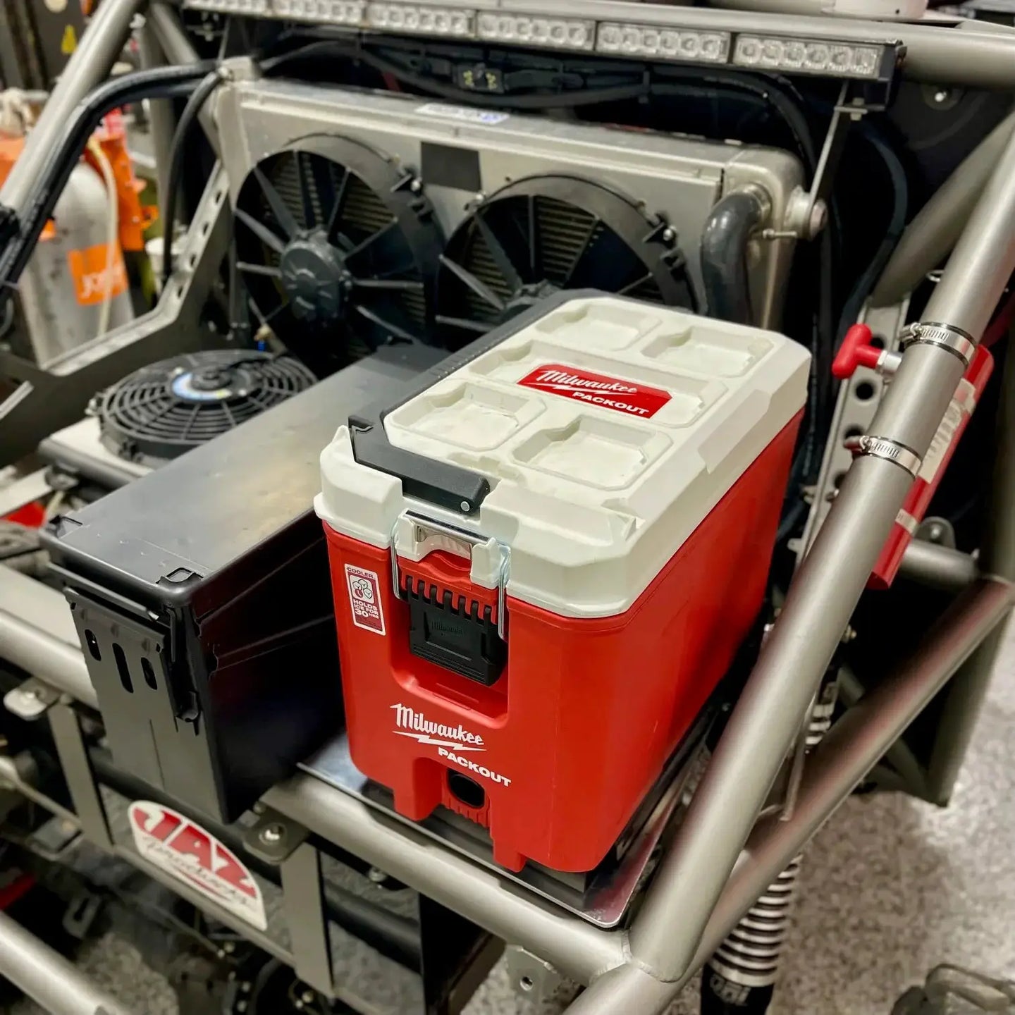 TMR Milwaukee Packout Single Mount Universal - red Packout cooler with white lid mounted in a vehicle roll cage