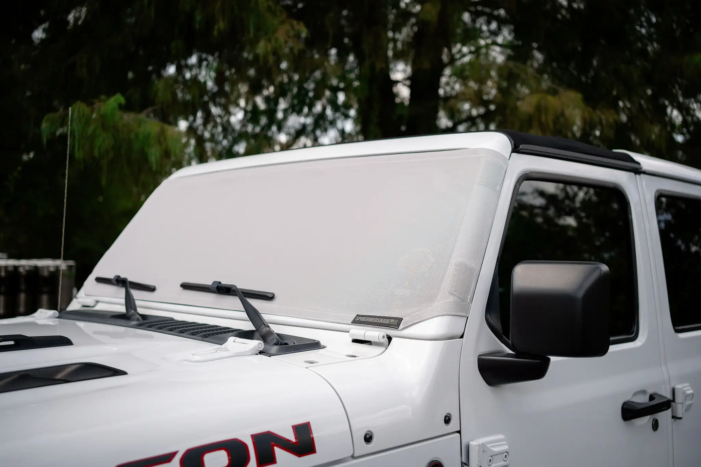 Solar shade by SpiderWebShade for Jeep Wrangler and Gladiator (2007–2026) on a white Jeep windshield