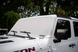 Solar shade by SpiderWebShade for Jeep Wrangler and Gladiator (2007–2026) on a white Jeep windshield