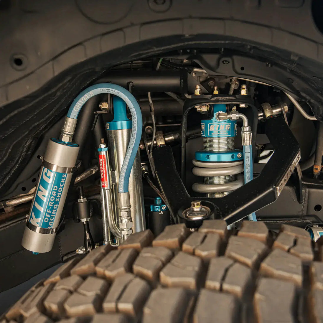 Dirt King Long Travel Kit for Toyota; blue anodized coilover shocks with hoses and fittings in wheel well