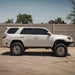 Dirt King Long Travel Kit for Toyota; coilover suspension parts on fence with white Toyota SUV below