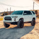 Dirt King Long Travel Kit Toyota white SUV, front-left view