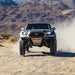 Long Travel Kit Dirt King for Toyota pickup — front suspension with blue shocks and steel skid plate