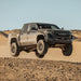 Dirt King 2.5 Coilovers DCA Remote Reservoir Toyota Tacoma front suspension visible in desert off-road scene