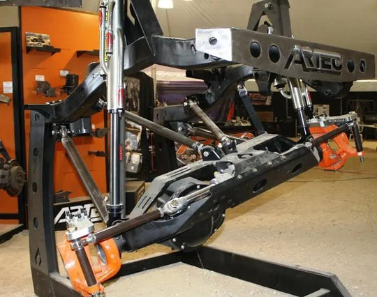 Artec Industries 4 Link Tube and End Kit on black suspension links with orange rod ends